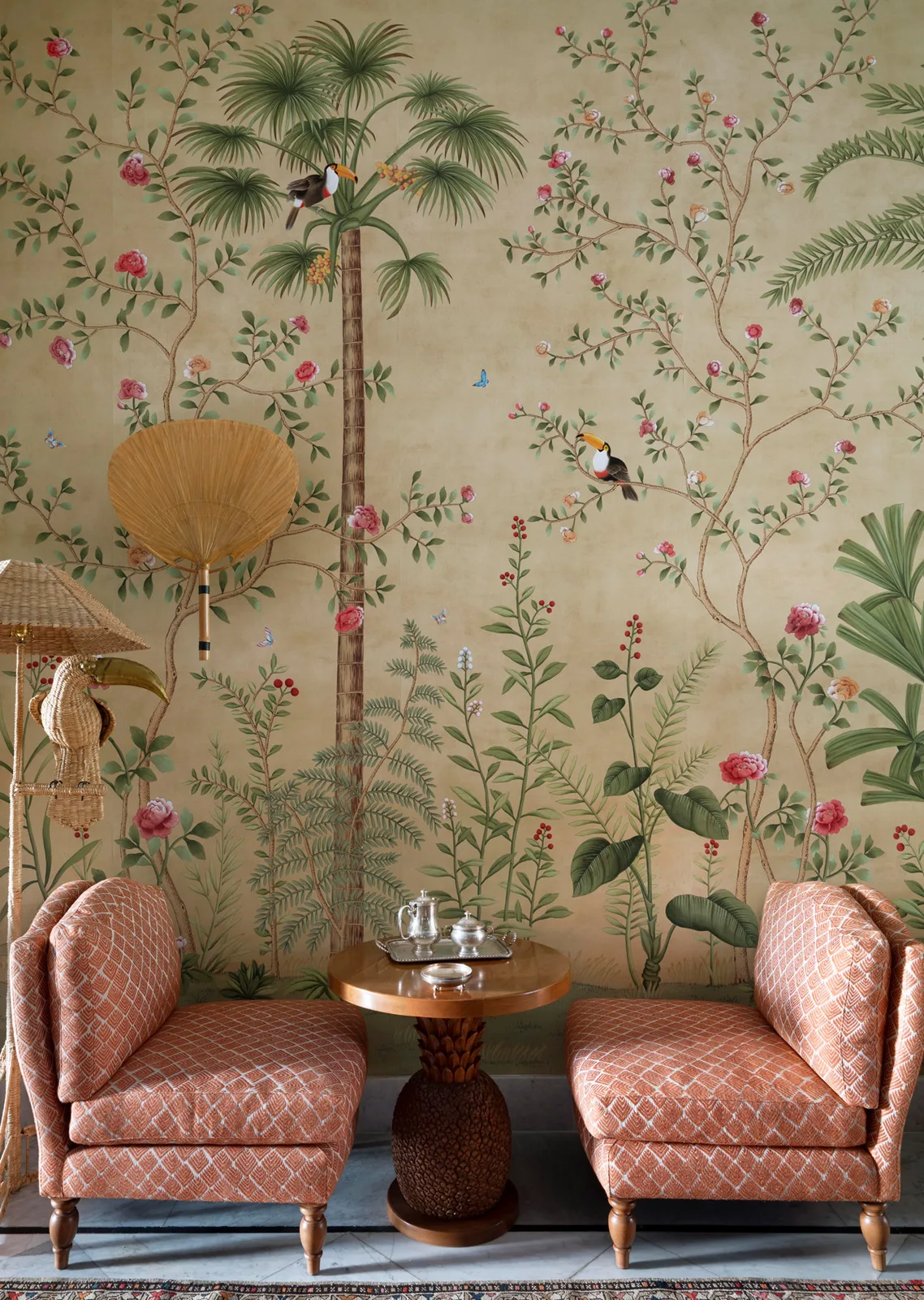 De Gournay Amazonia hand-painted wallpaper surrounding a pair of pink armchairs