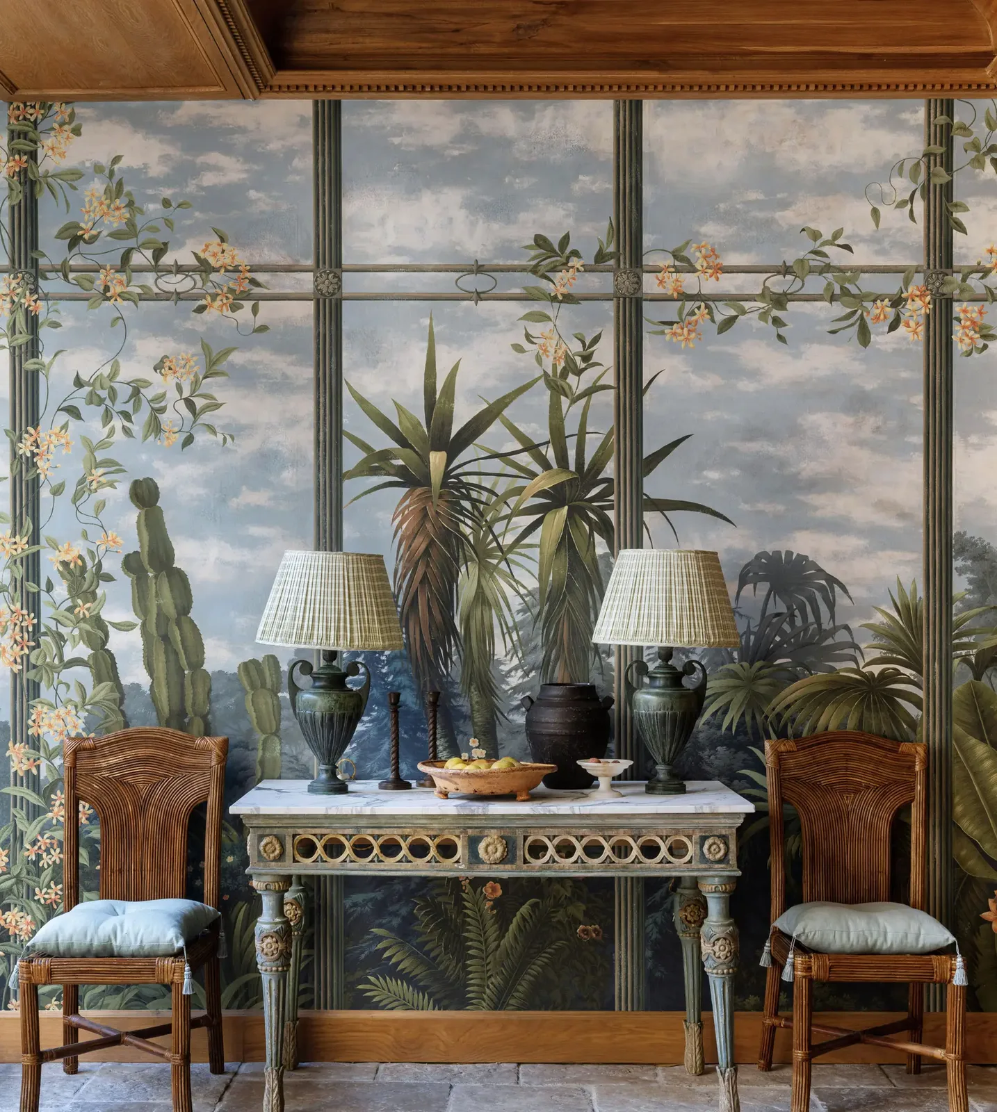 De Gournay hand-painted scenic wallpaper in a blue and gold interior with a console and stools